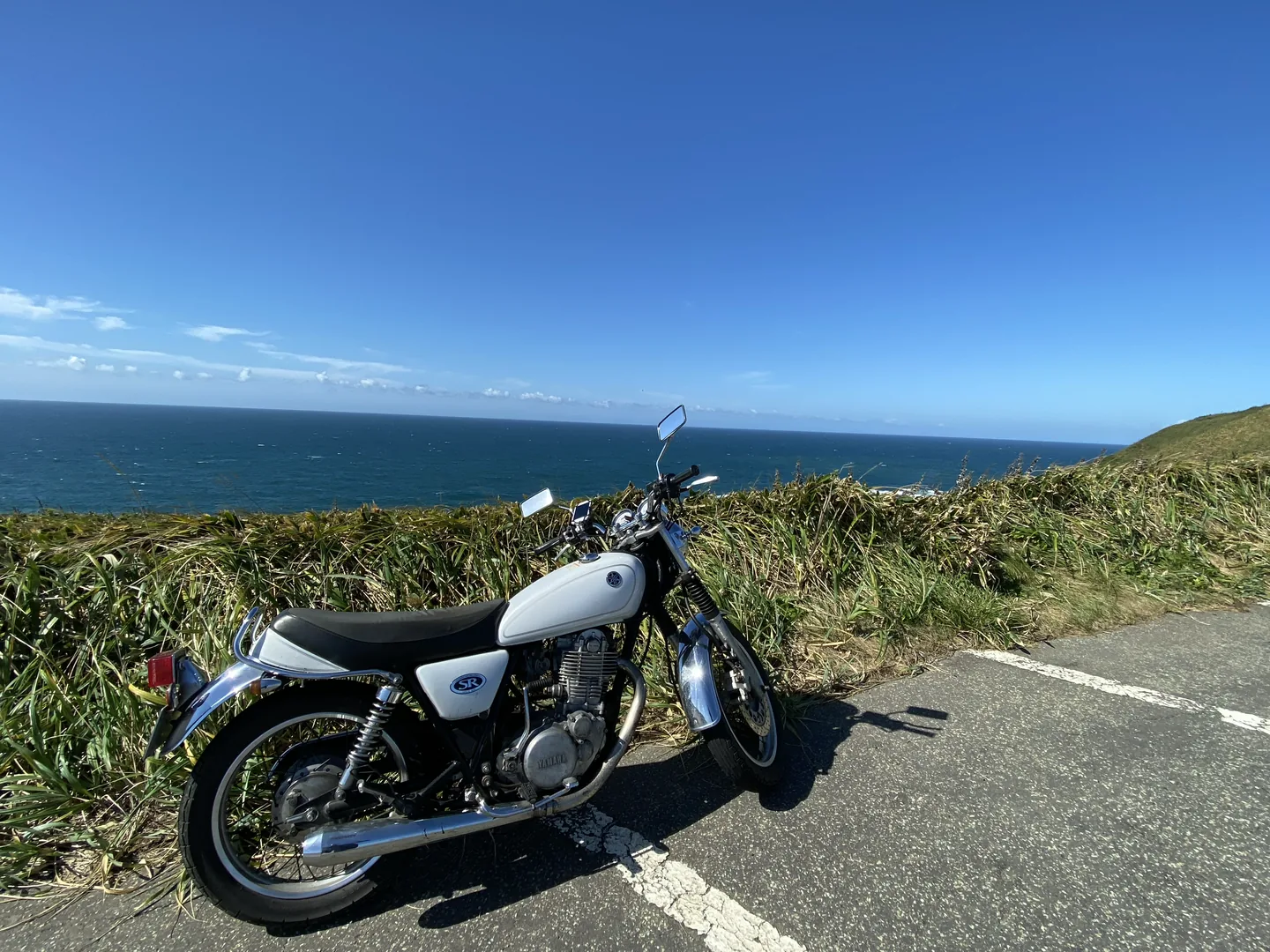 海沿いの道に停めたSR400。奥に水平線が見える